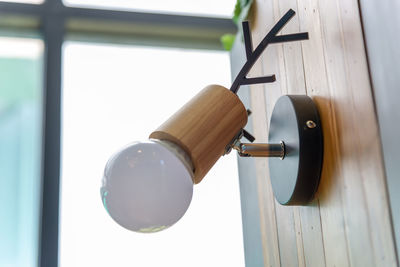 Low angle view of electric lamp hanging on door
