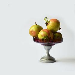 Close-up of apples on table against white background