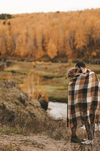 Rear view of couple standing on rock