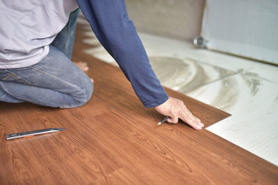 Low section of man working on wooden table