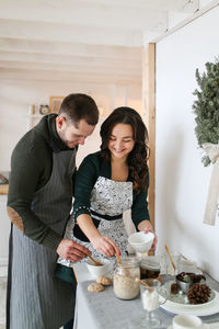 A happy couple in love are preparing for the christmas holiday in the decorated kitchen of the house
