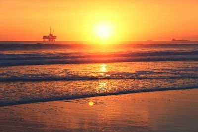 Scenic view of sea against orange sky