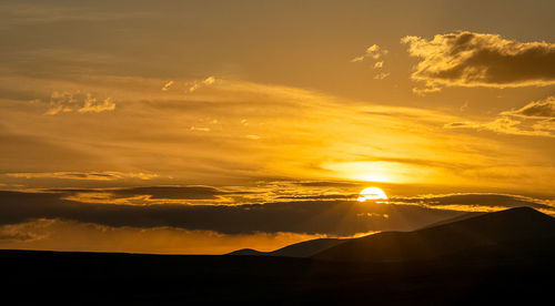 Scenic view of silhouette mountains against sky during sunset