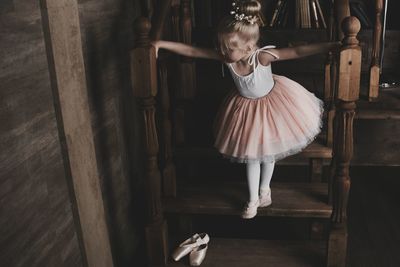 High angle view of ballet dancer standing on steps at home