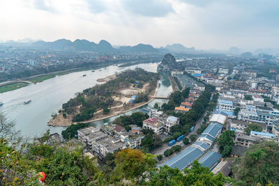 High angle view of townscape by sea against sky