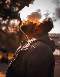 Rear view of man standing against sky during sunset