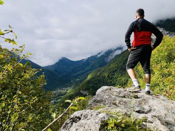 Jeune homme au bord de la falaise regardant le paysage