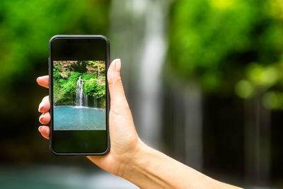 Midsection of person holding mobile phone