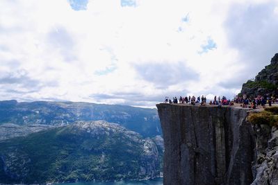 People on mountain against sky