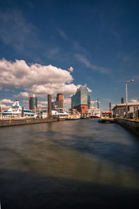 View over a river to the elbe philharmonic hall, skyline with ships and buildings at the waterfront