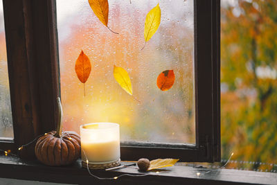 Still life details in home on a wooden window. sweater, candle, hot tea and autumn decor