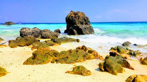 Scenic view of rock formation in sea against sky