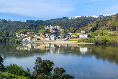 Scenic view of lake by buildings against sky