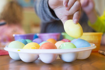 Midsection of woman holding egg on table