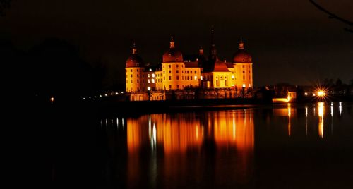 Reflection of illuminated building in lake at night