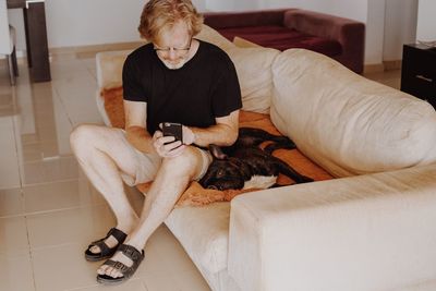 Man with dog sitting at home