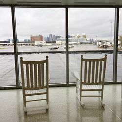 Chairs and table by river against sky