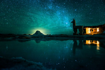 Scenic view of lake against sky at night
