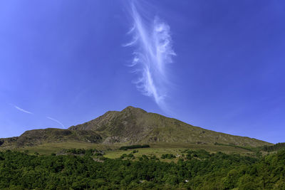 Low angle view of mountain against blue sky