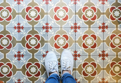 Low section of man standing on tiled floor