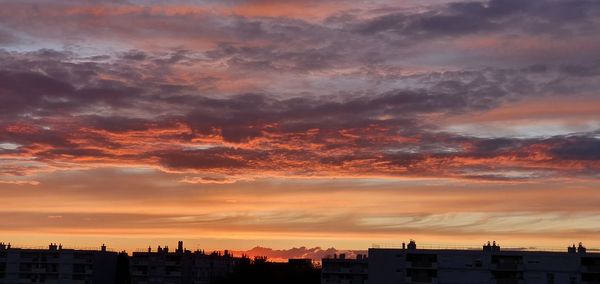 Silhouette buildings against sky during sunset