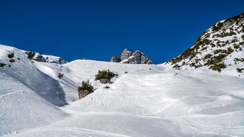 Scenic view of snowcapped mountains against clear blue sky