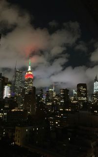 Illuminated buildings in city against sky at night