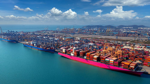 High angle view of city by sea against sky