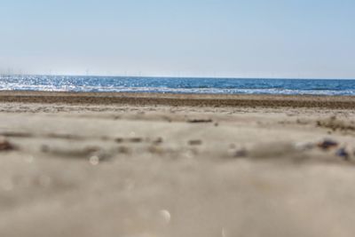 Surface level of beach against clear sky