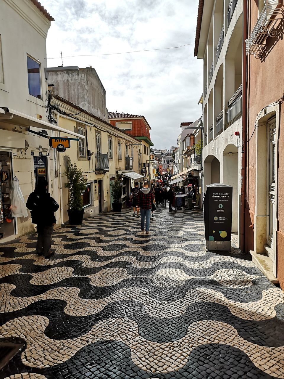 PEOPLE WALKING ON STREET BY BUILDINGS IN CITY