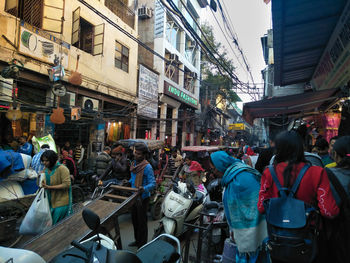 People on street amidst buildings in city