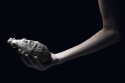 Close-up of woman hand against black background