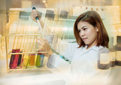 Multiple exposure of scientist doing experiment in laboratory