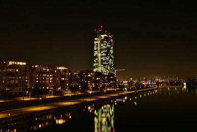 Illuminated buildings in city against sky at night