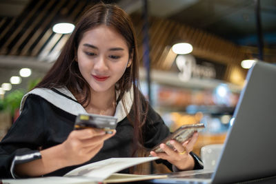 Portrait of young woman using mobile phone