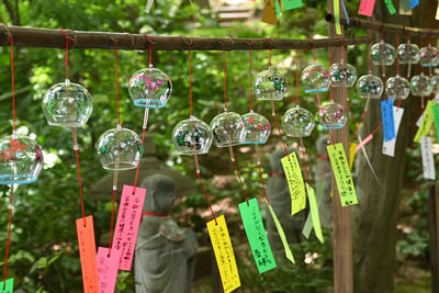 Close-up of decorations hanging in row for sale at market stall