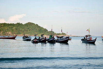 Boats moored in sea against sky