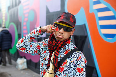 Low angle view of man wearing sunglasses standing outdoors