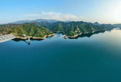 Scenic view of lake and mountains against blue sky