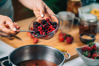 Midsection of man preparing fruits in bowl