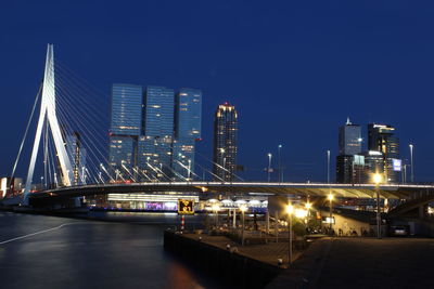 Illuminated bridge over river at night