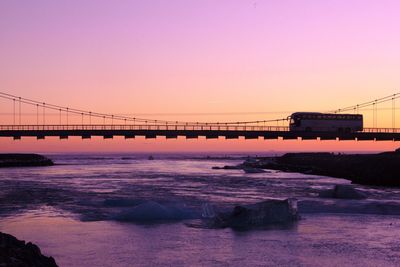 Bridge over sea against clear sky during sunset
