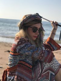 Side view of young woman standing at beach