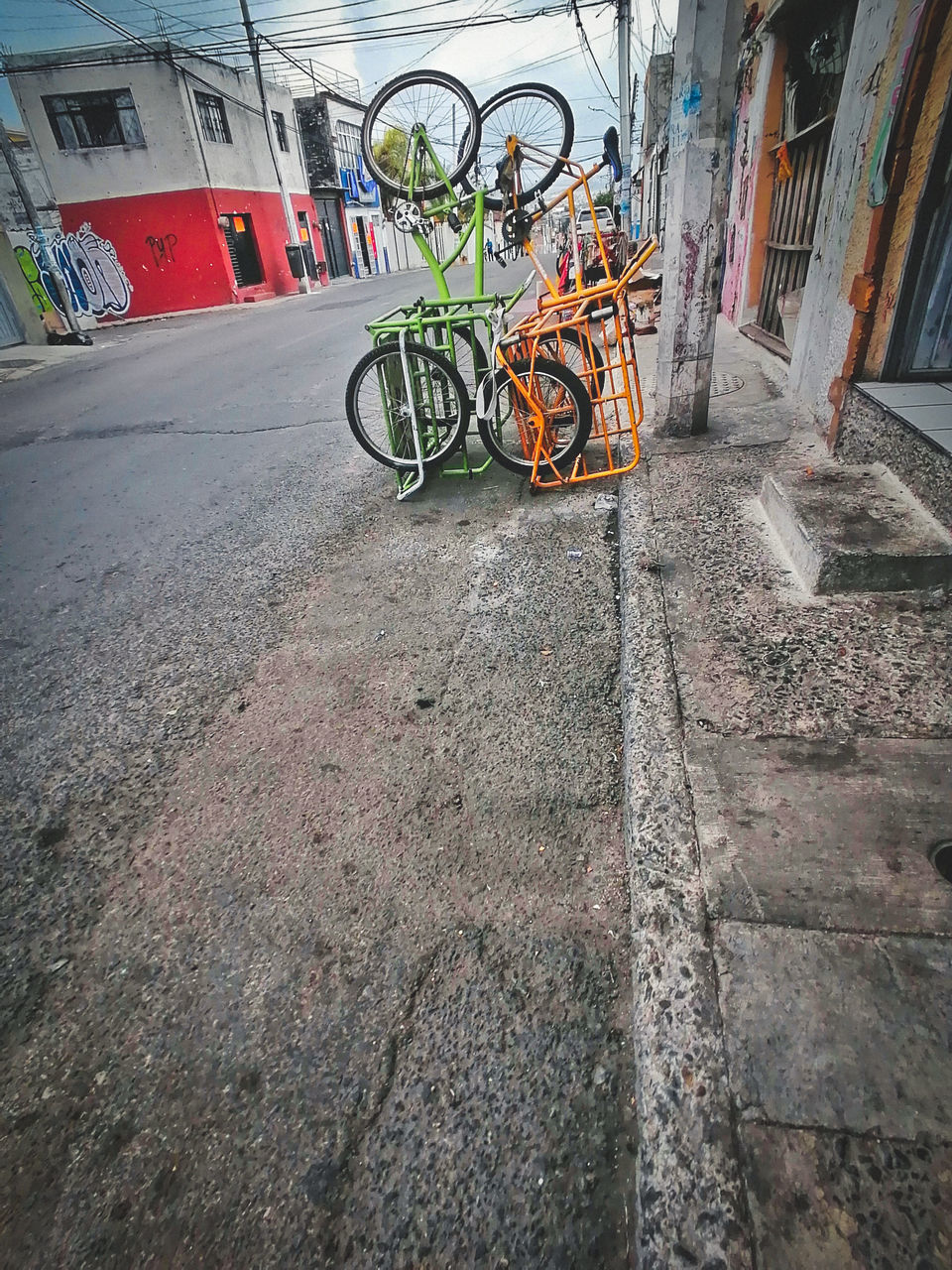 BICYCLE PARKED ON STREET BY WALL