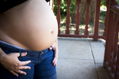 Midsection of woman wearing hat standing outdoors