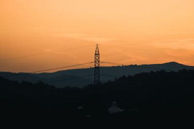 Silhouette electricity pylon against sky during sunset