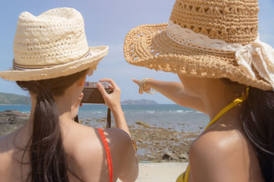 Rear view of woman wearing hat on beach