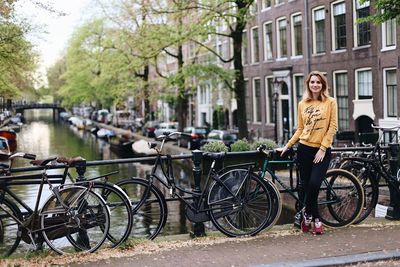 Bicycles parked by canal in city