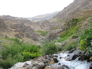 Scenic view of river amidst mountains against sky