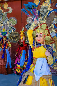 Full length of woman with multi colored umbrellas in traditional clothing